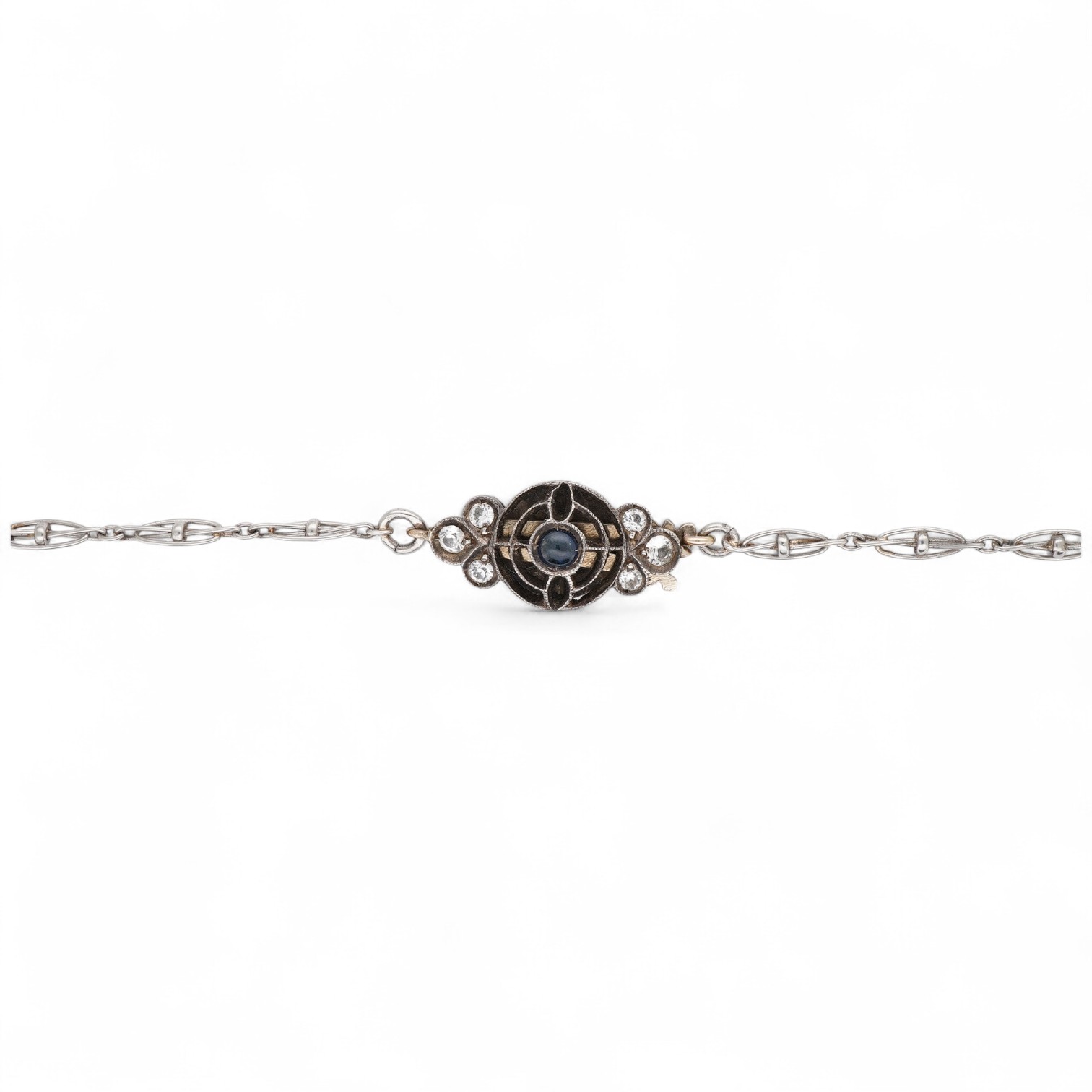 A platinum chain necklace, early 20th century, of fancy linking, to a cabochon sapphire and paste clasp, length 49cm, indistinct assay mark